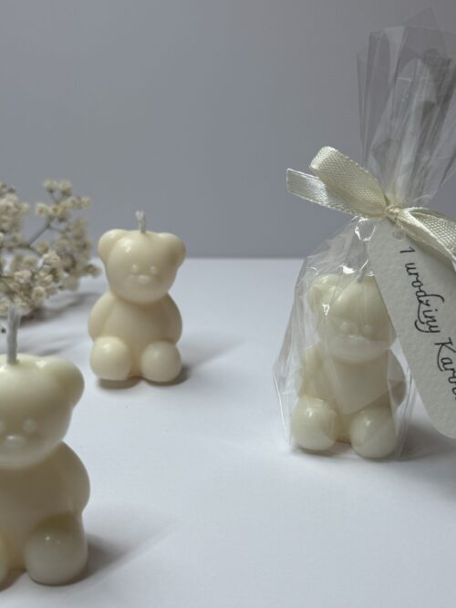 Świece sojowe w kształcie misia z personalizowaną winietką, w tle gipsówka