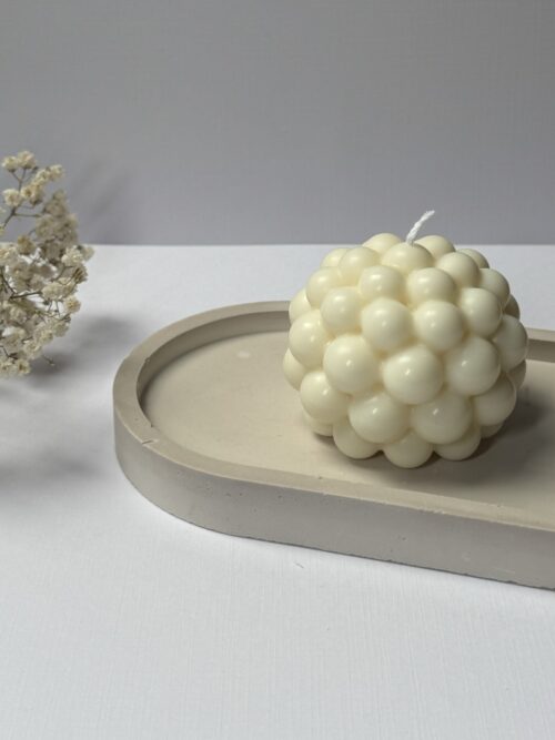 Świece sojowe w kształcie kuli bubble na podstawce gipsowej, w tle gipsówka