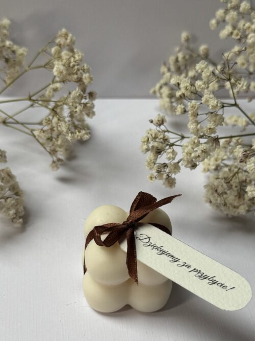 Świece sojowe w kształcie mini bubble ze wstążką i personalizowaną winietką, w tle gipsówka