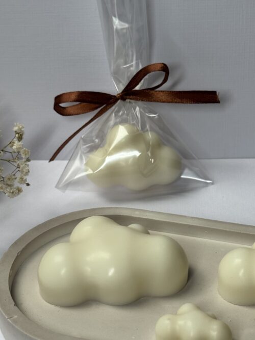 Świeca sojowa w kształcie chmurki na podstawce gipsowej, w tle gipsówka