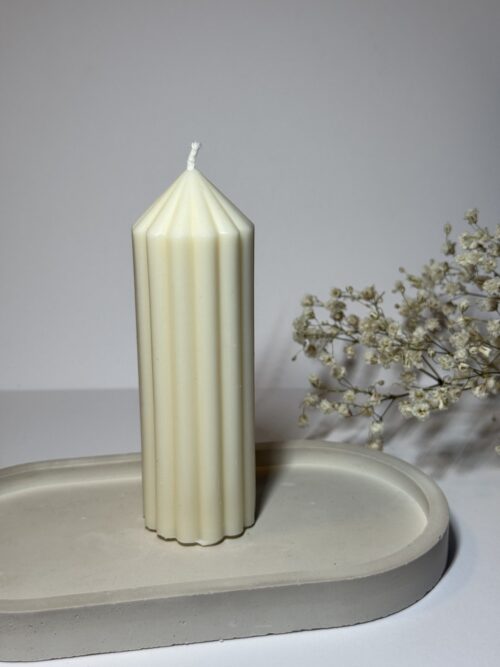 Wysoka świeca sojowa na podstawce gipsowej, w tle gipsówka