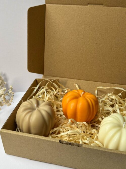 Świeca sojowa w kształcie dyni w 3 kolorach, zapakowane w pudełko prezentowe, w tle gipsówka