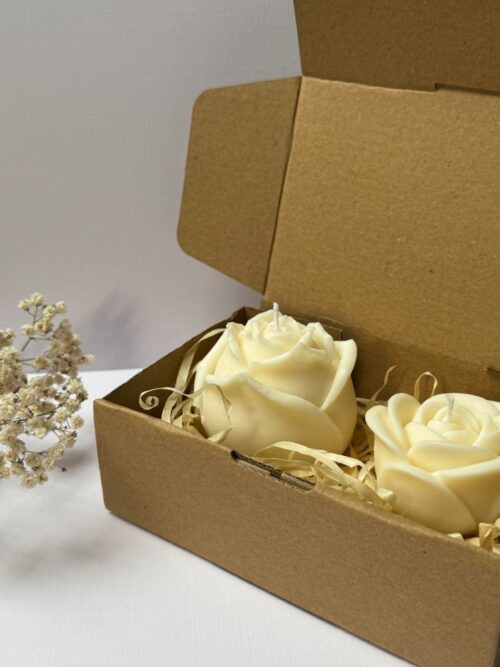 Świece sojowe w kształcie róży, zapakowane w pudełko prezentowe, w tle gipsówka