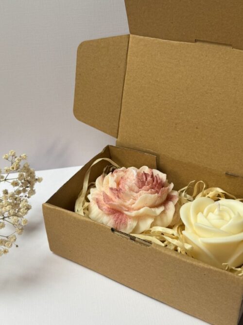 Świece sojowe w kształcie piwonii i róży, zapakowane w pudełko prezentowe, w tle gipsówka